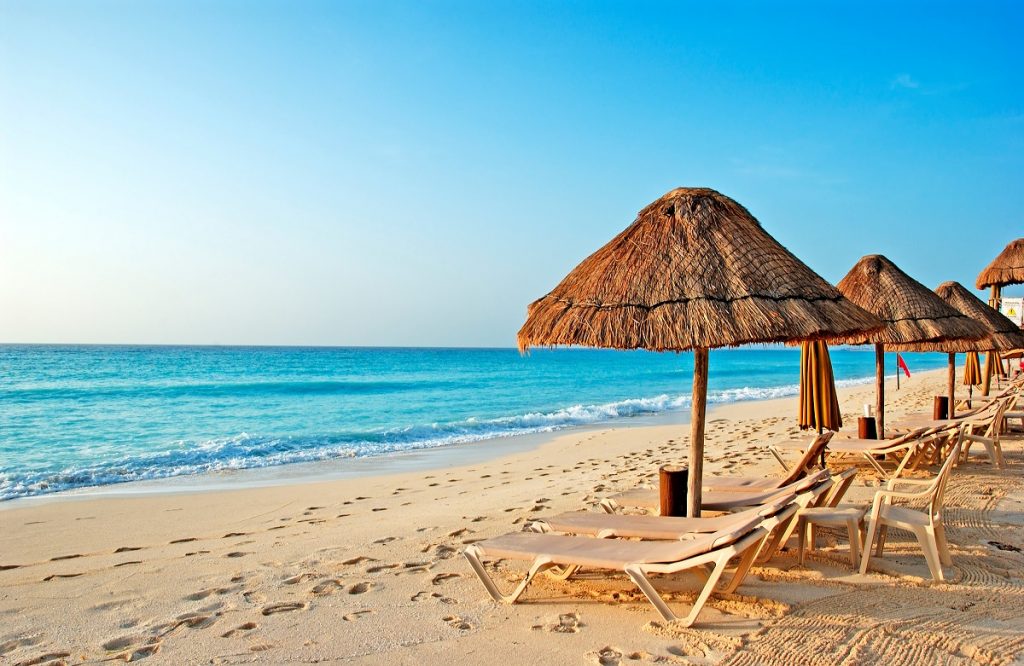 A beautiful beach set up with lounge chairs and umbrellas