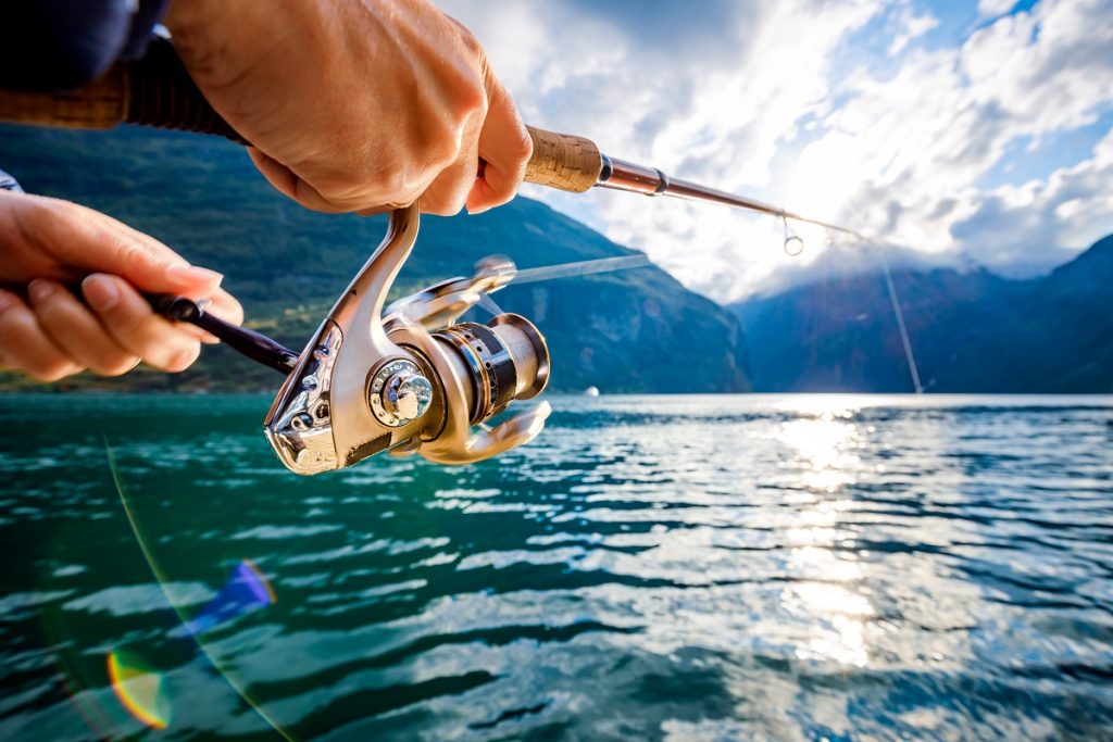A close-up of a person fishing on beautiful blue water