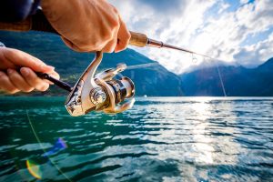 A close-up of a person fishing on beautiful blue water